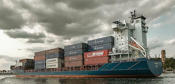 Dunkle Wolken über einem Containerschiff