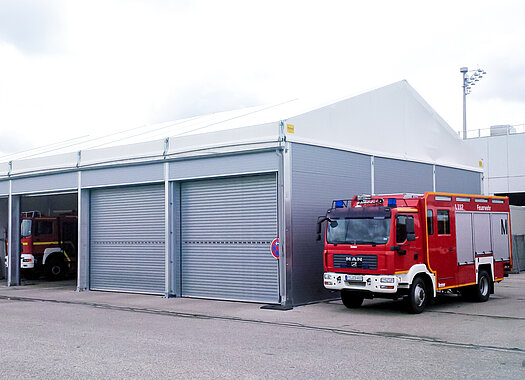 Feuerwehrhalle mit Toren und Fahrzeugen